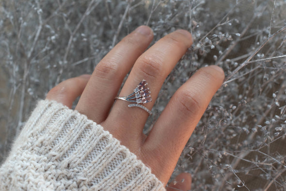 Mano con anillo en plata 925 en forma de flor con tres rosas que rematan en Zirconias color rosa exhibido en Guatemala